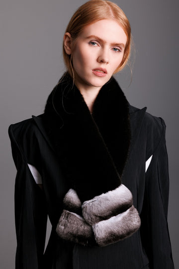 Woman wearing a black coat with ranch mink and chinchilla scarf