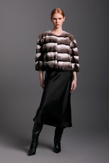 black cross mink jacket  in horizontal pattern on woman wearing a silk dress
