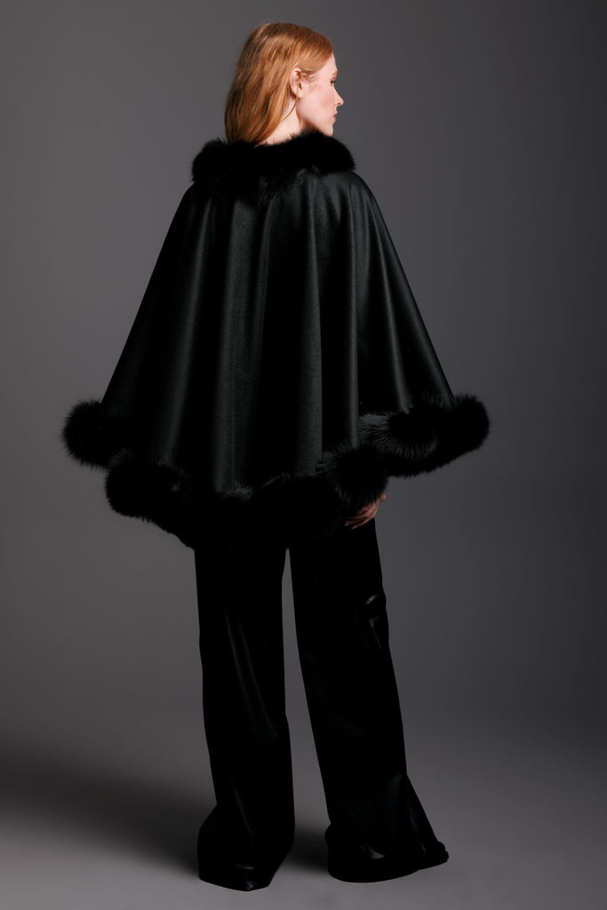 woman wearing a black cashmere cape with fur trim and black leather pants in petite size