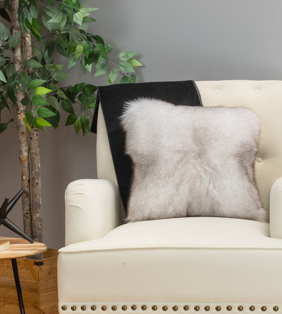 blue fox fur pillow on white sofa chair in living room