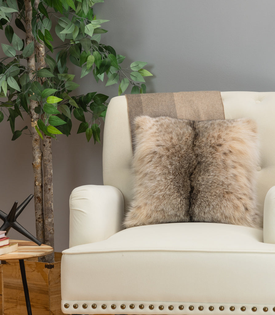 canadian lynx fur pillow on white sofa chair in living room