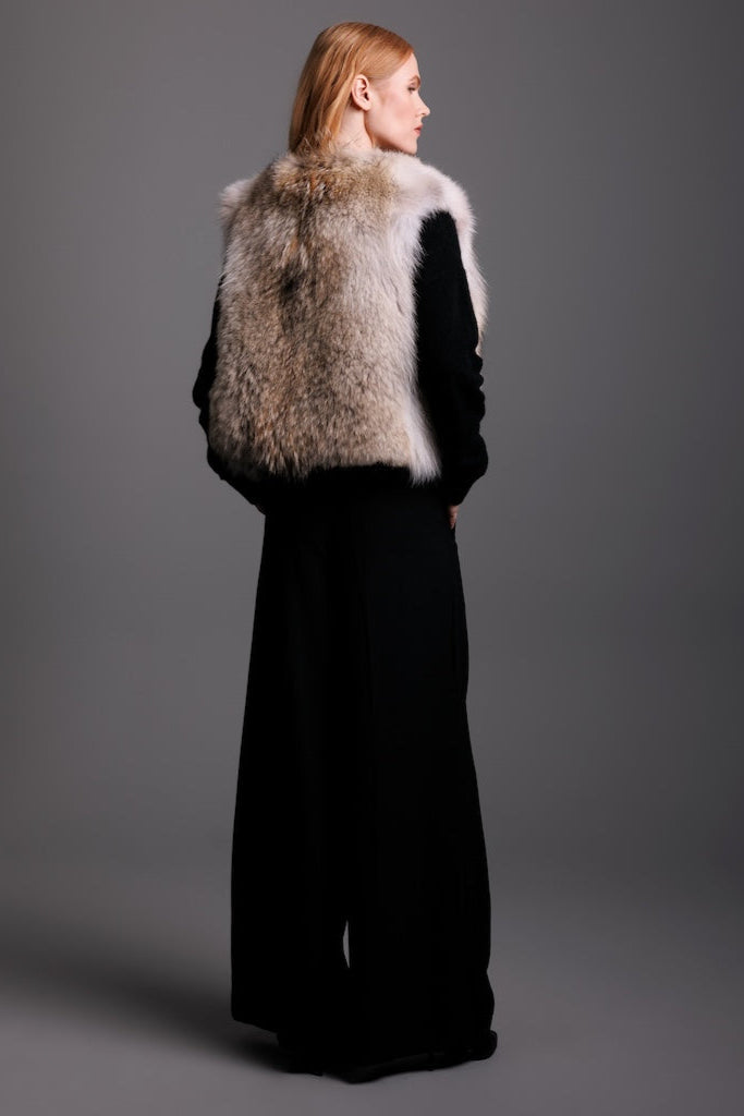 coyote cropped fur vest on woman wearing black pants backside view