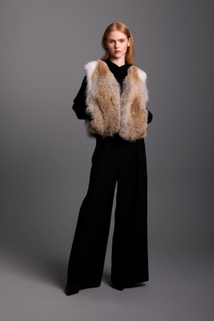 coyote fur short vest on woman wearing black wide pants