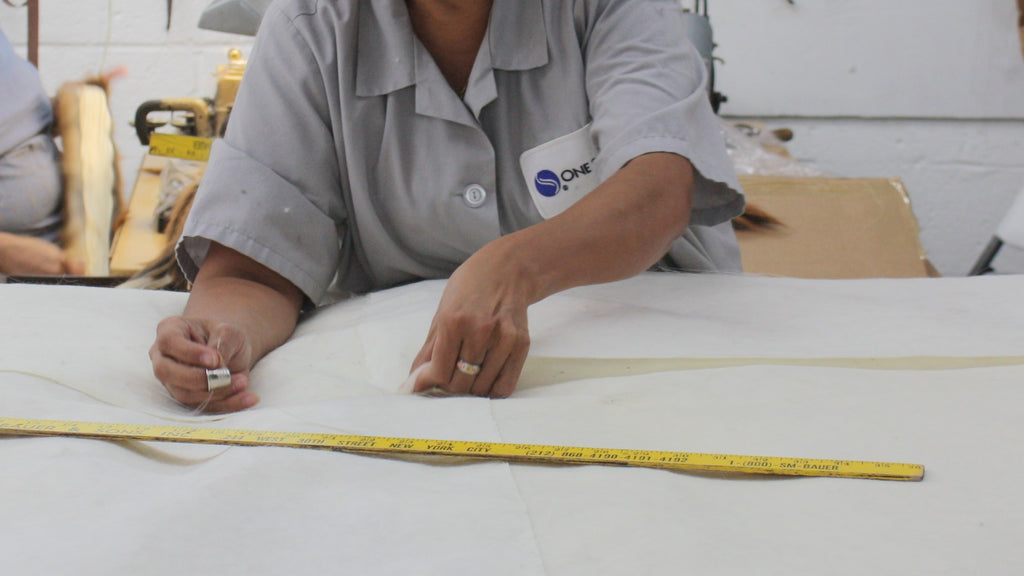 factory worker hand sewing blush fox fur rug