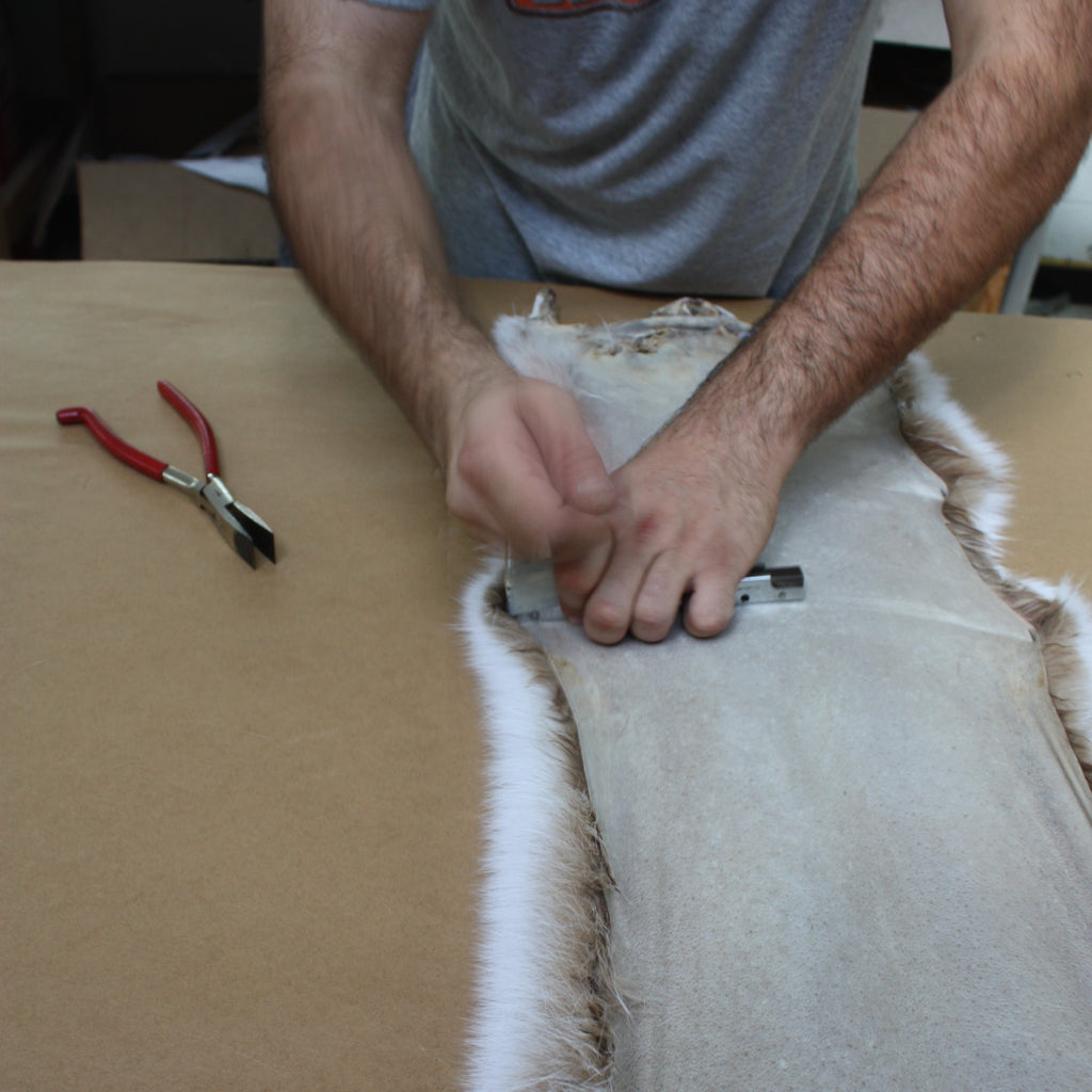 professional worker nailing down blush fox fur skins to board