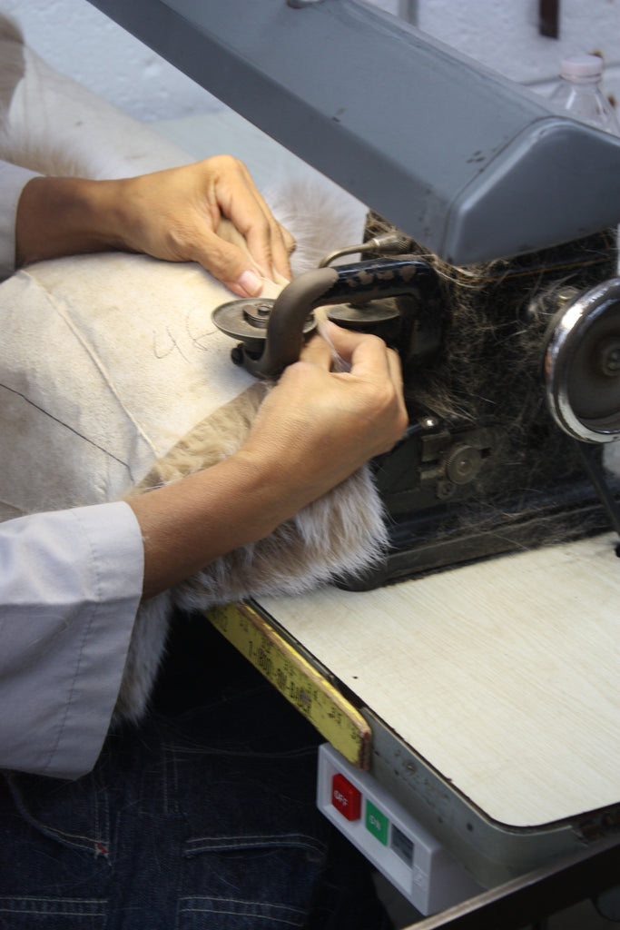 machine sewing photo of a blush fox fur rug in a factory