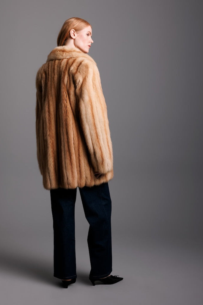 golden sable fur jacket backside fur detail view on woman wearing dark jeans