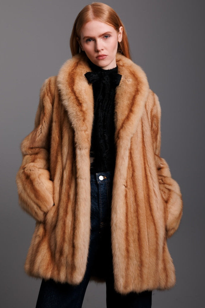 woman wearing golden sable fur jacket and pussy blouse in fronta view
