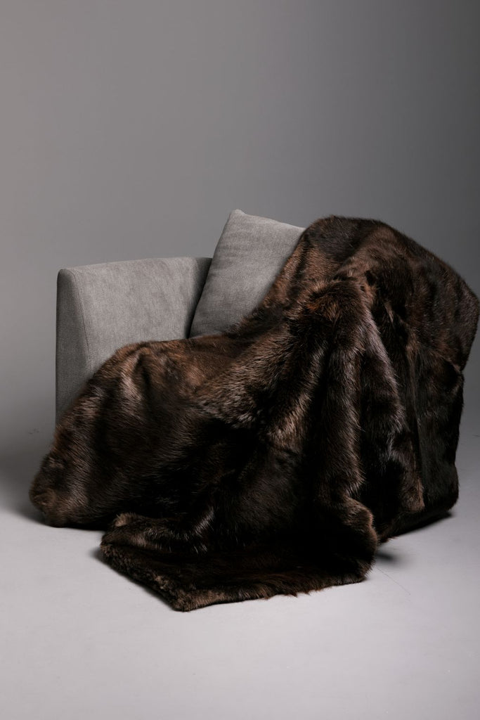 real beaver fur blanket with cashmere backing hanging over a grey living room chair in throw, queen, king, custom size