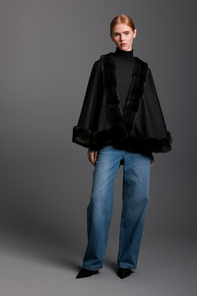 woman wearing mink trim cape with black cashmere and jeans and heels 