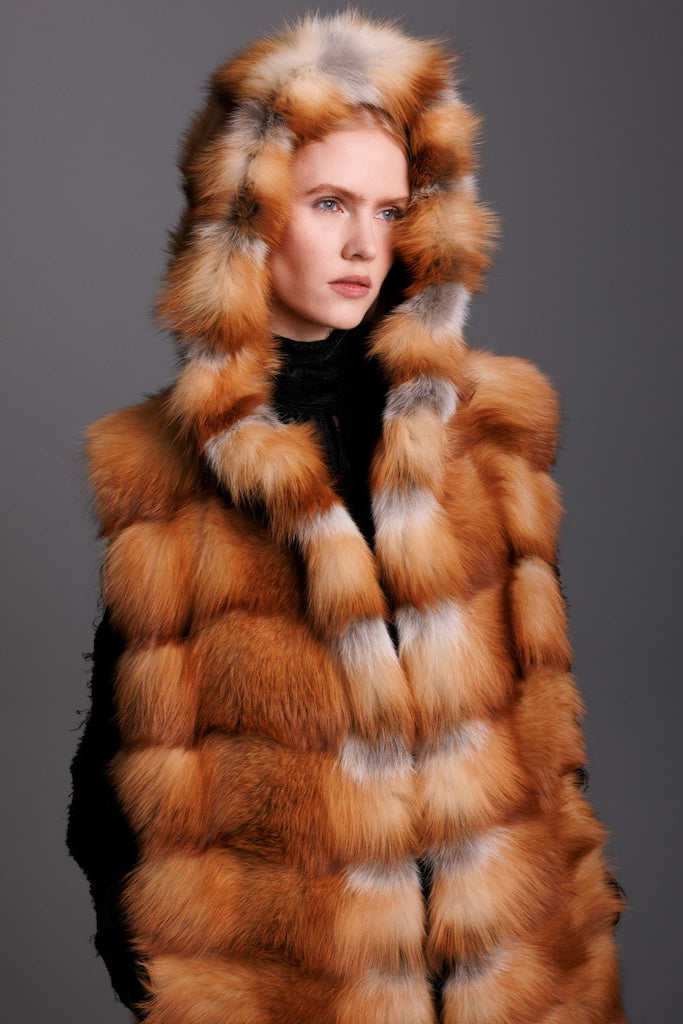 red fox fur hooded real fur vest in a horizontal pattern detailed close up veiw on a woman wearing black pants and heels