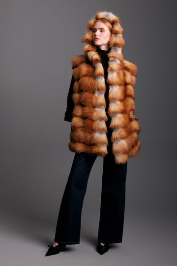 red fox fur hooded real fur vest in a horizontal pattern on a woman wearing black pants and heels
