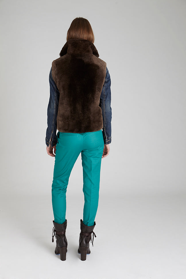 model wearing sheared beaver fur vest with denim jacket and green pants showing back detail