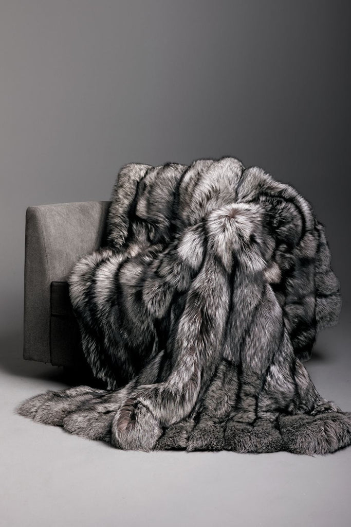 silver fox fur blanket with black cashmere backing draped over a grey living room chair throw, queen, king and custom sizing
