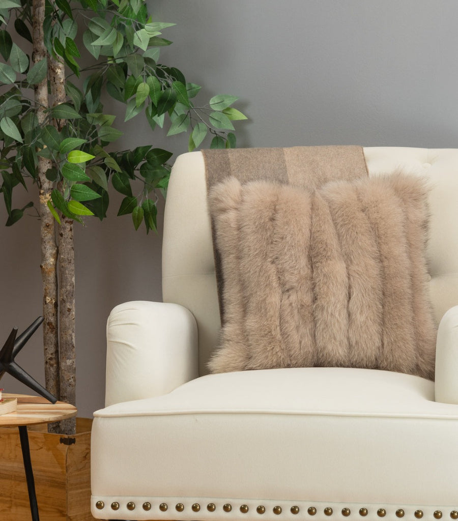 taupe fox fur pillow in vertical design on sofa chair living room setting