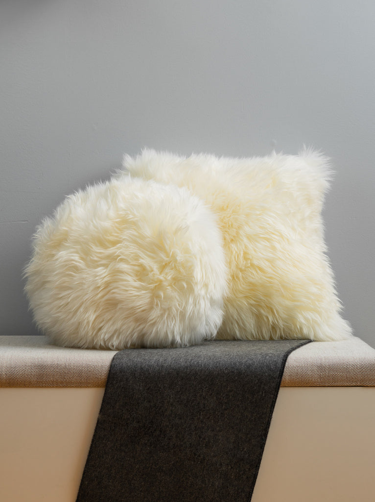 white shearling fur pillow set on bench