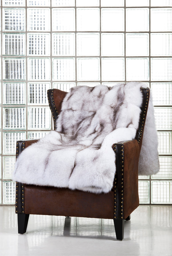 Blue fox fur blanket draped over sofa chair for interior design