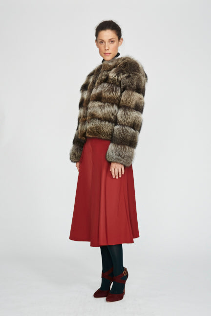 Raccoon fur in horizontal cut short jacket styled on model wearing a red skirt