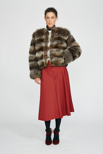 Raccoon fur in horizontal cut short jacket styled on model wearing a red skirt