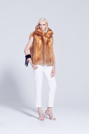 Red fox fur winter vest with cross cut design collar worn with winter white pants